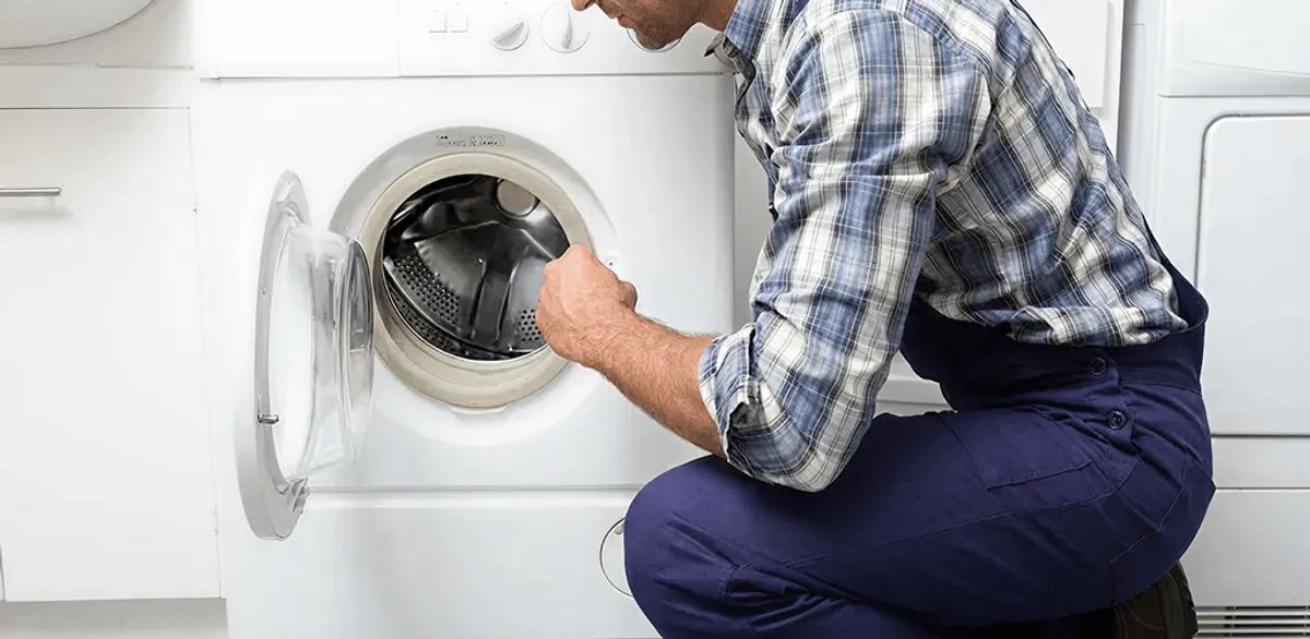 Handyman inspecting a dryer drum and internal parts for repair in Henderson, NV