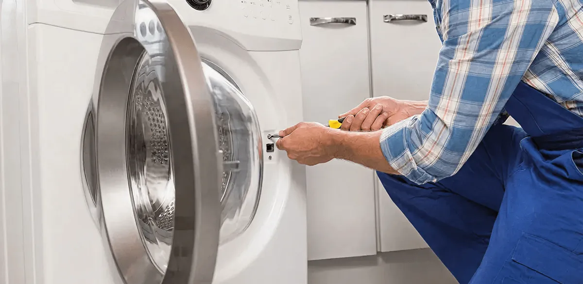 Handyman repairing a clothes dryer and checking electrical connections in Henderson, NV