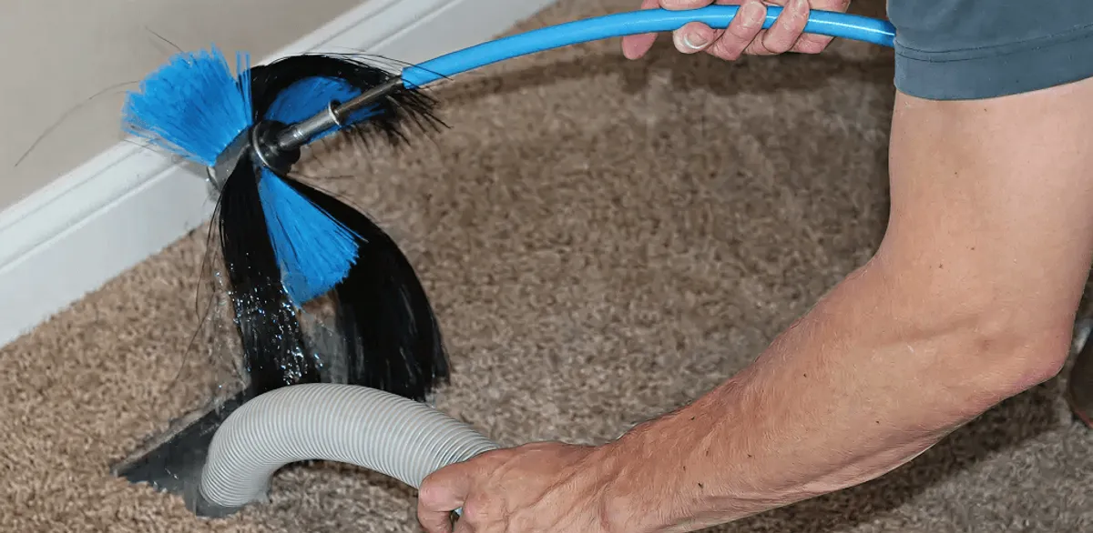 Dryer vent cleaning technician brushing lint from a vent line in Henderson, NV