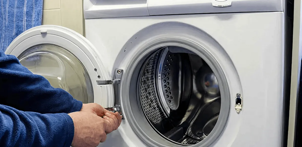 Washing machine repair handyman checking a front-load washer door and latch in Henderson, NV